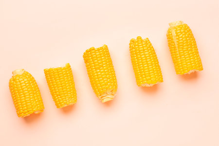 Cut fresh corn cobs on pink backgroundの写真素材
