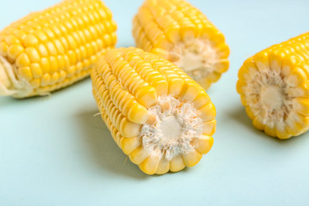 Cut fresh corn cobs on blue background