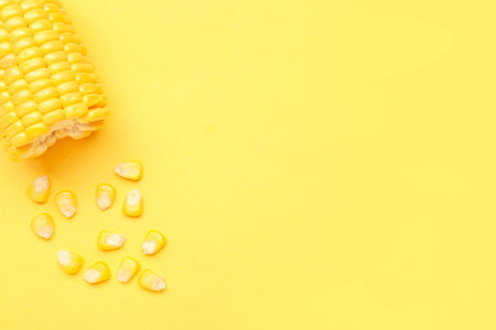 Cut fresh corn cob and seeds on yellow backgroundの写真素材