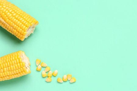 Cut fresh corn cobs and seeds on turquoise background