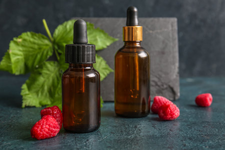 Bottles of cosmetic raspberry oil on dark backgroundの写真素材
