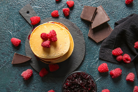 Board of tasty pancakes with raspberries on black backgroundの写真素材