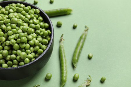 Bowl with fresh green peas on color backgroundの写真素材