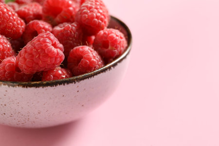 Bowl with fresh raspberries on pink backgroundの写真素材
