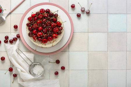 Plate with tasty cherry cake on white tile backgroundの写真素材