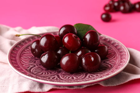 Plate with sweet cherry on colorful backgroundの写真素材