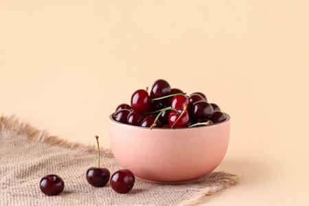 Bowl with sweet cherry on orange backgroundの写真素材