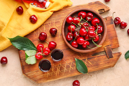 Wooden board with shots of sweet cherry liqueur on pink backgroundの写真素材