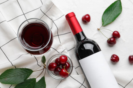 Glass and bottle with sweet cherry liqueur on white backgroundの写真素材