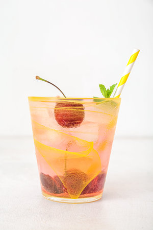 Glass of tasty cherry lemonade with mint on white backgroundの写真素材