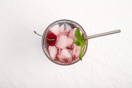 Glass of tasty cherry lemonade with mint on white backgroundの写真素材