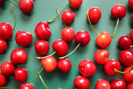 Many sweet cherries on green background