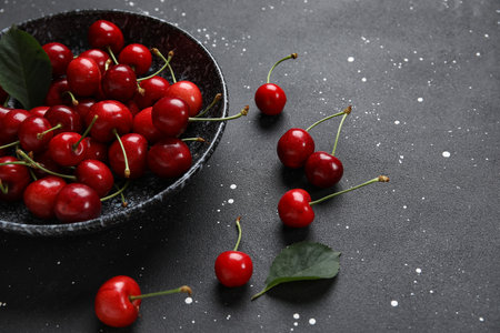Bowl with sweet cherry on black backgroundの写真素材