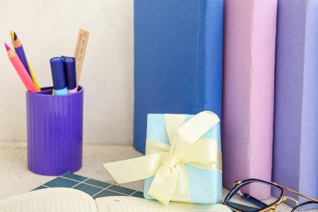Gift box with eyeglasses, books and different stationery on white tableの写真素材