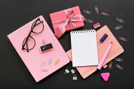 Gift box with eyeglasses and different stationery on black chalkboard