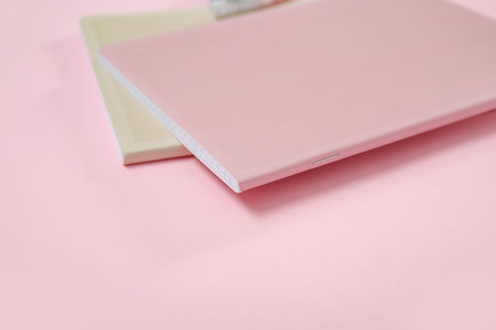 Different notebooks on pink background