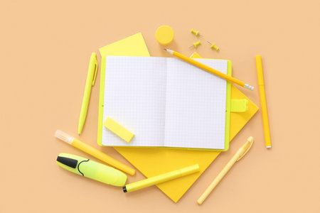 Blank notebook with different stationery on beige background