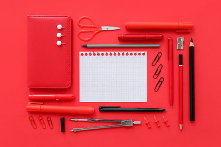 Blank notebook with different stationery on red backgroundの写真素材