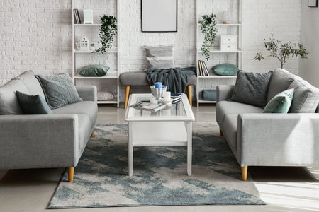 Interior of light living room with cozy gray sofas and coffee table