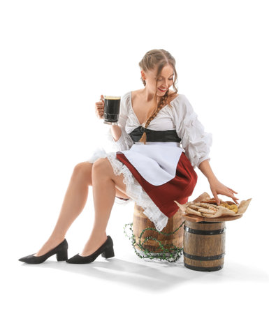 Beautiful Octoberfest waitress with beer and snacks sitting on white backgroundの写真素材