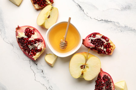 Composition with bowl of honey and fruits on light background, closeup. Rosh hashanah (Jewish New Year) celebrationの写真素材