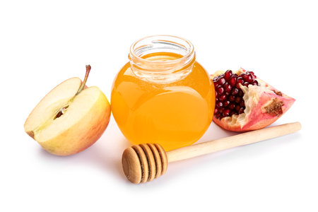 Jar of sweet honey, dipper, ripe apple and pomegranate on white background. Rosh hashanah (Jewish New Year) celebrationの写真素材