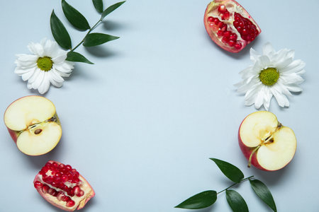 Composition with fresh fruits, flowers and plant leaves on light background, closeup. Rosh hashanah (Jewish New Year) celebrationの写真素材
