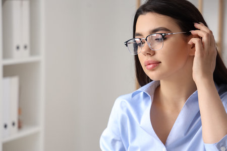 Beautiful young woman wearing glasses in officeの写真素材