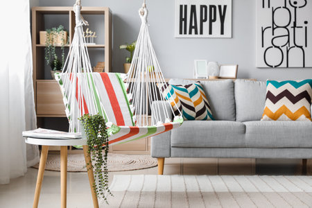 Interior of stylish living room with striped hammock and gray sofaの写真素材