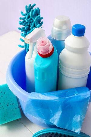Bowl with different cleaning supplies on light wooden table, closeupの写真素材