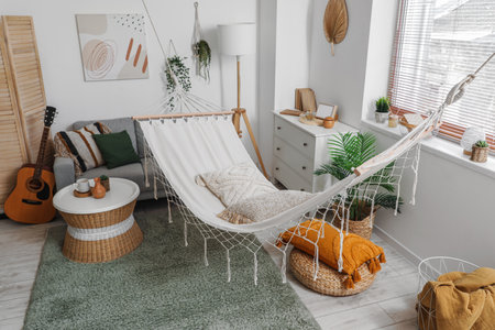 Interior of stylish living room with hammock, gray sofa and coffee tableの写真素材
