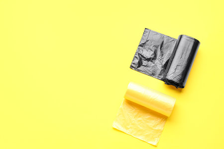 Different rolls of garbage bags on yellow backgroundの写真素材
