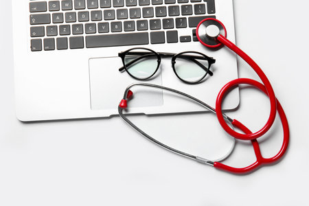 Stethoscope, laptop and glasses on white backgroundの写真素材