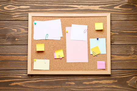 Board with different sticky notes on wooden backgroundの写真素材