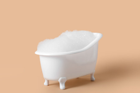 Small bathtub with foam on color backgroundの写真素材
