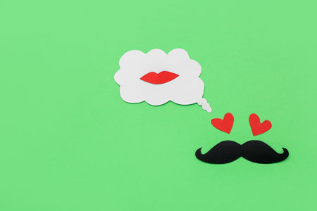 Paper male face and speech bubble with lips on green background. Dialogue conceptの写真素材