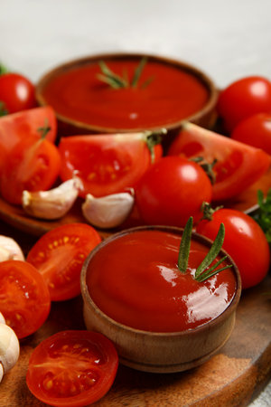 Bowl with tasty ketchup and fresh vegetables on tableの写真素材