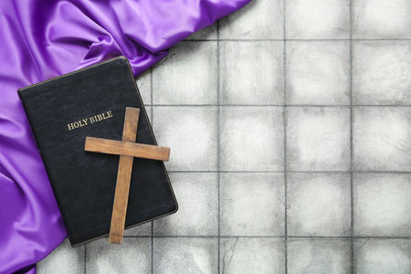 Holy Bible with wooden cross and purple fabric on gray tile background. good friday conceptの写真素材