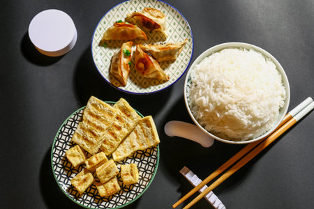Tasty Chinese food and chopsticks on dark backgroundの写真素材