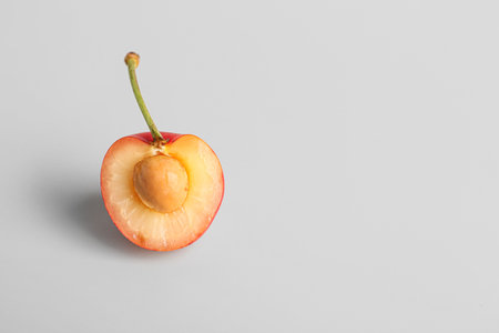 Half of sweet yellow cherry on gray backgroundの写真素材