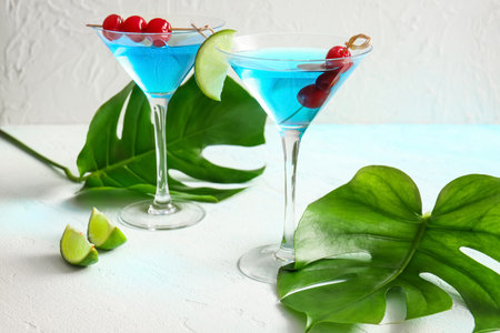 Glasses of tasty cocktail with maraschino cherries on light backgroundの写真素材