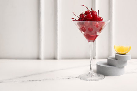 Glass of tasty maraschino cherries on tableの写真素材
