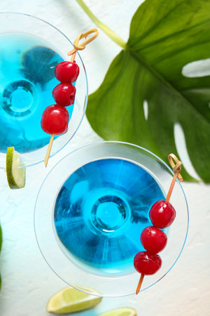 Glasses of tasty cocktail with maraschino cherries on light backgroundの写真素材