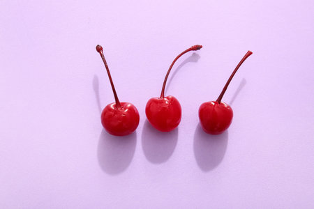 Tasty maraschino cherry on lilac backgroundの写真素材