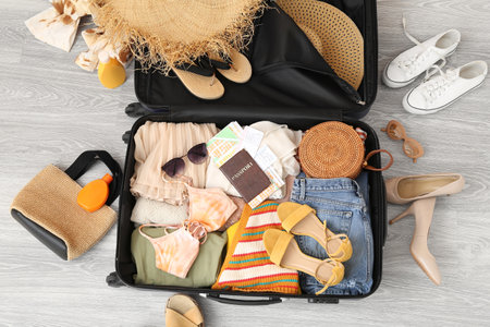 Suitcase with clothes, beach accessories, passports and tickets on the floor. travel conceptの写真素材