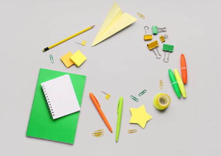 Frame made of blank notebook and stationery supplies on gray backgroundの写真素材