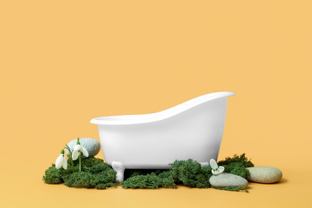 Composition with small bathtub, moss and snowdrops on color backgroundの写真素材