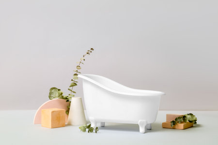Small bathtub, plaster decor and eucalyptus branches on light backgroundの写真素材