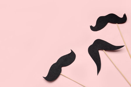 Wooden sticks with paper mustaches on pink backgroundの写真素材