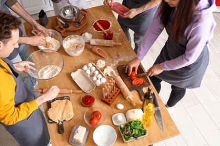 Group of young people with chef preparing Italian pizza during cooking class in kitchenの写真素材